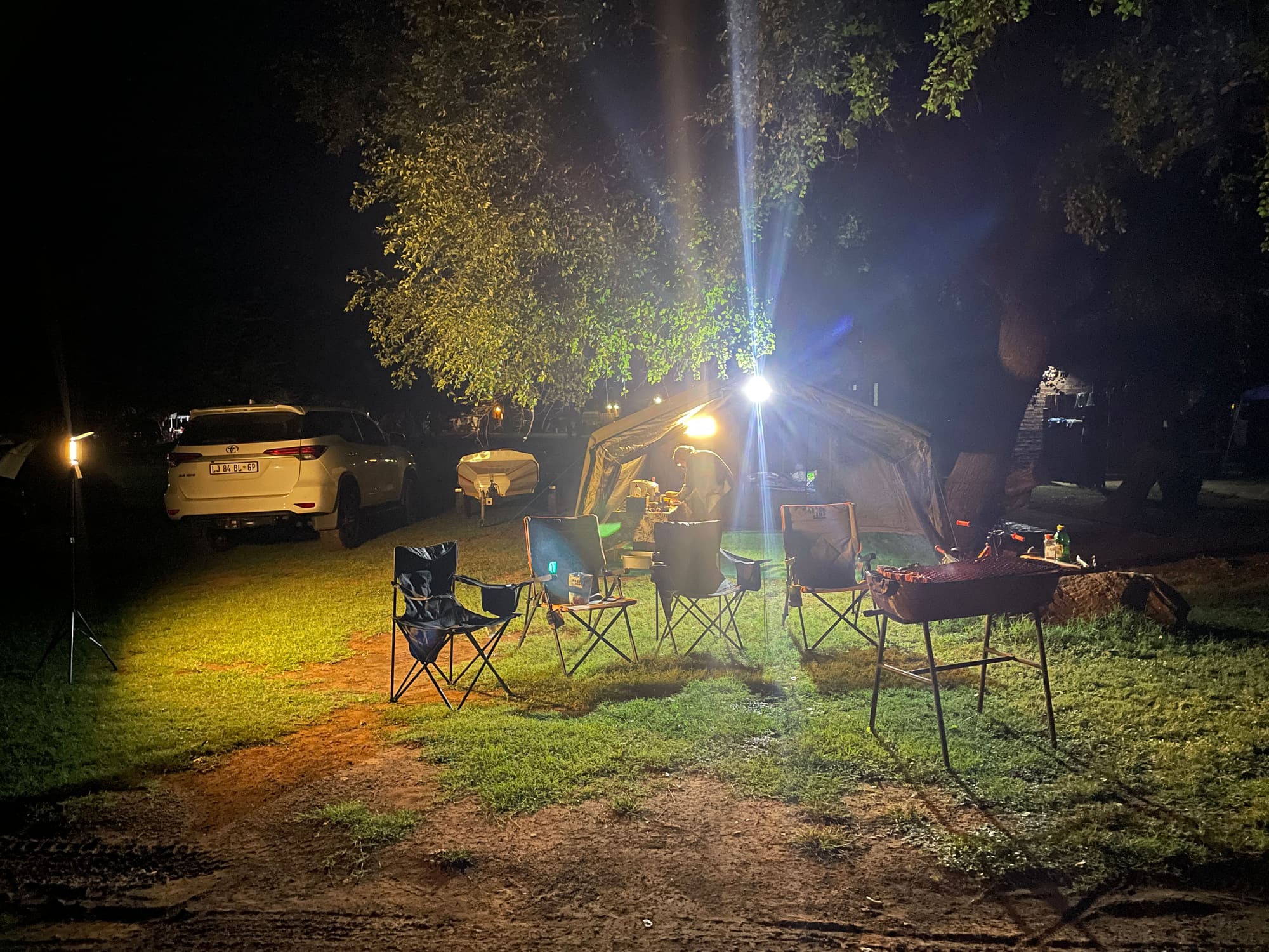 Family gathered around the fire at night at the Sondela, Bela Bela campsite