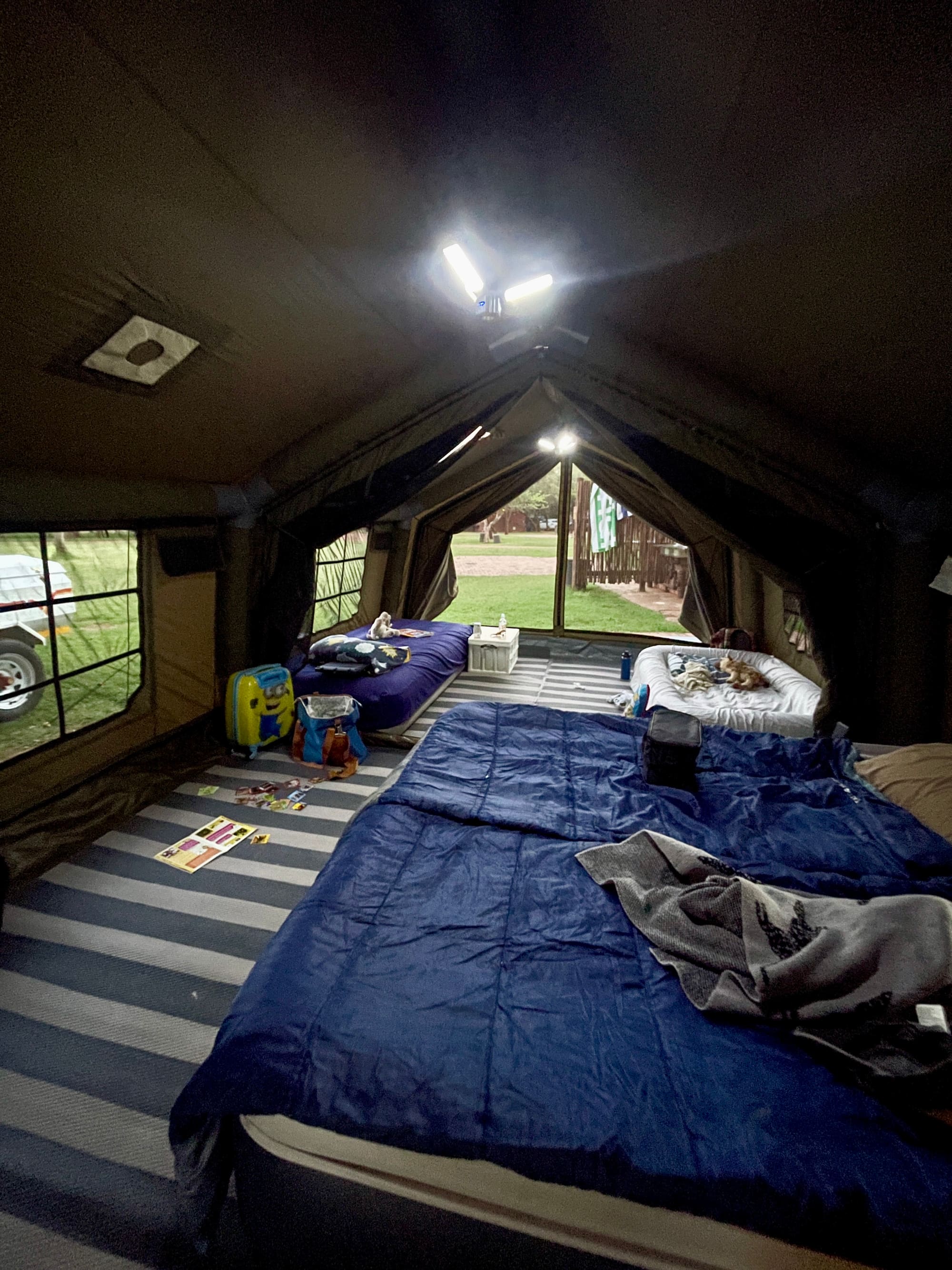 Kids' beds and toys inside the Coody Familia tent at night, lit by camp light at Sondela, Bela Bela