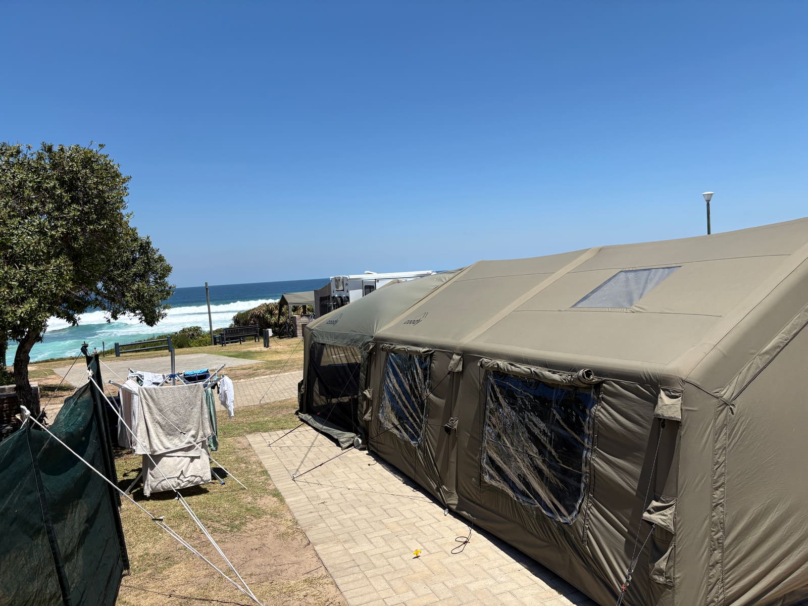 Coody Familia tent alongside the washing line, ocean in the background