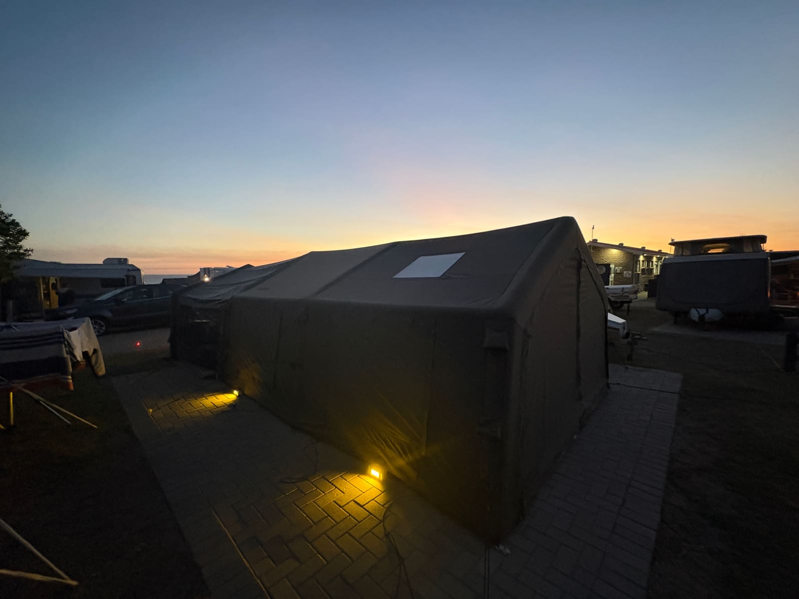 Coody Familia tent at dusk with ground lights glowing