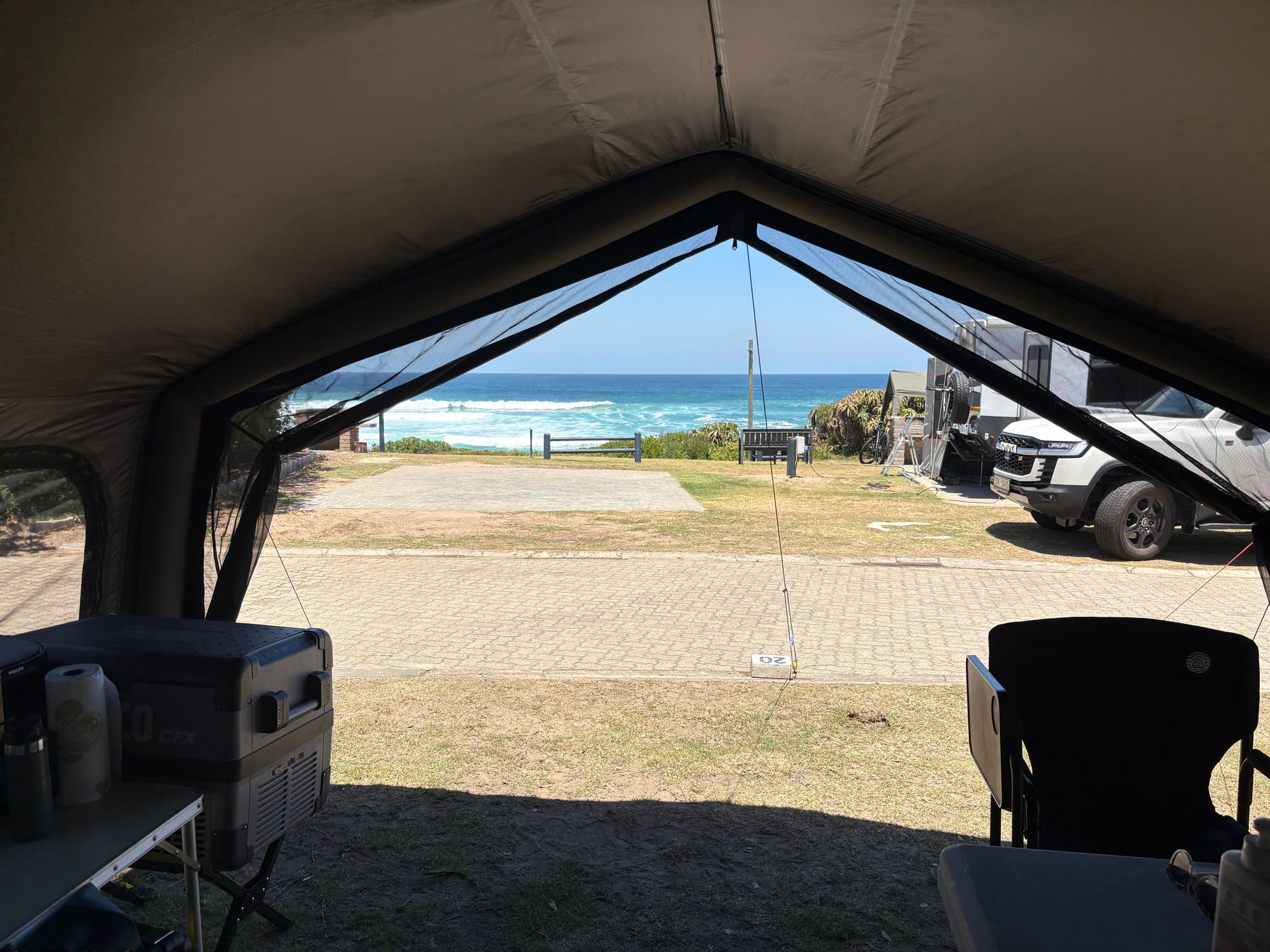 View from inside the Coody Familia tent at Dwarswegstrand, looking out through the mesh doorway straight onto the beach and ocean