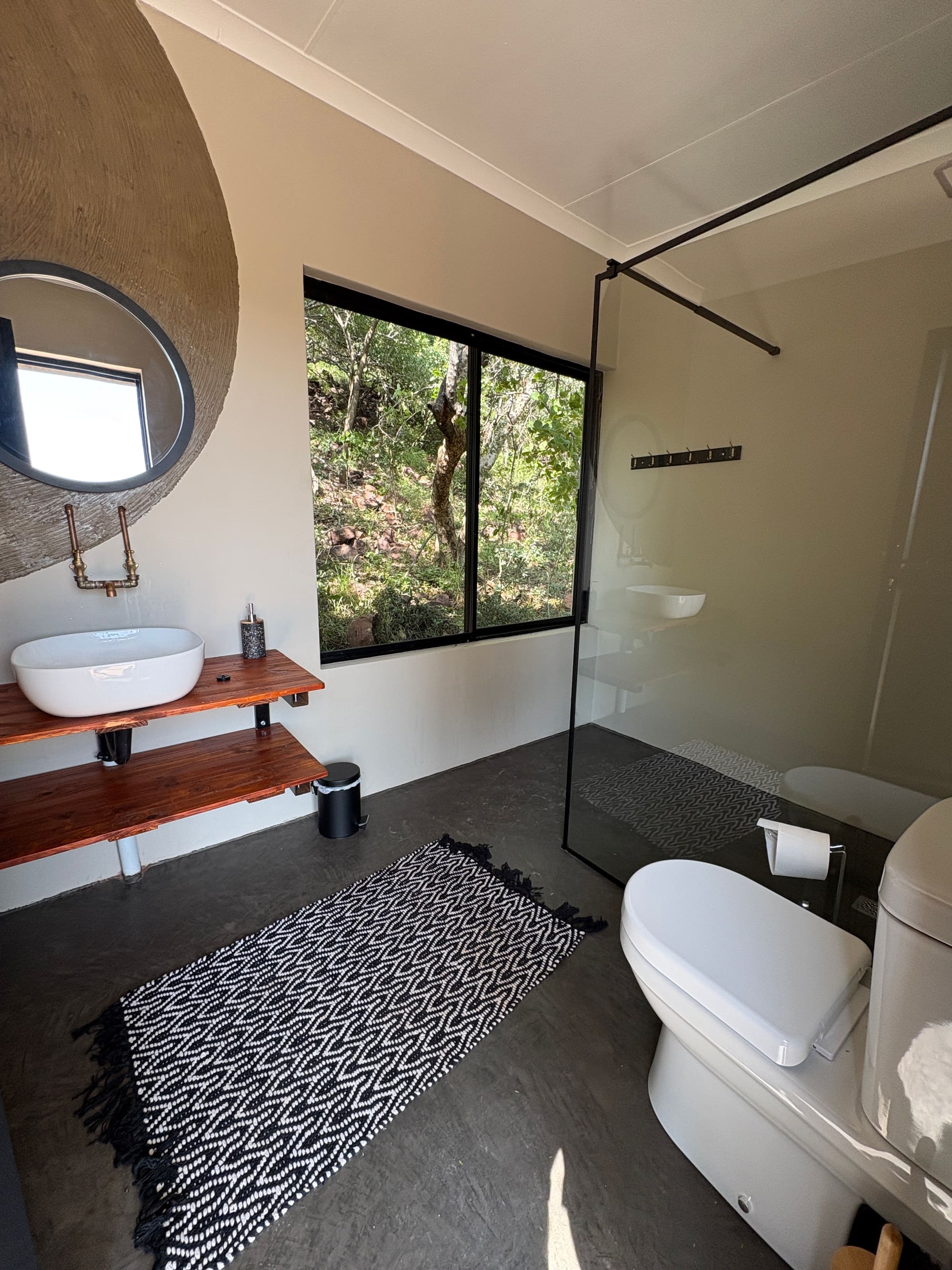 Interior of the ensuite bathroom at Kleinood Guest Farm, with a view of the bush through the window