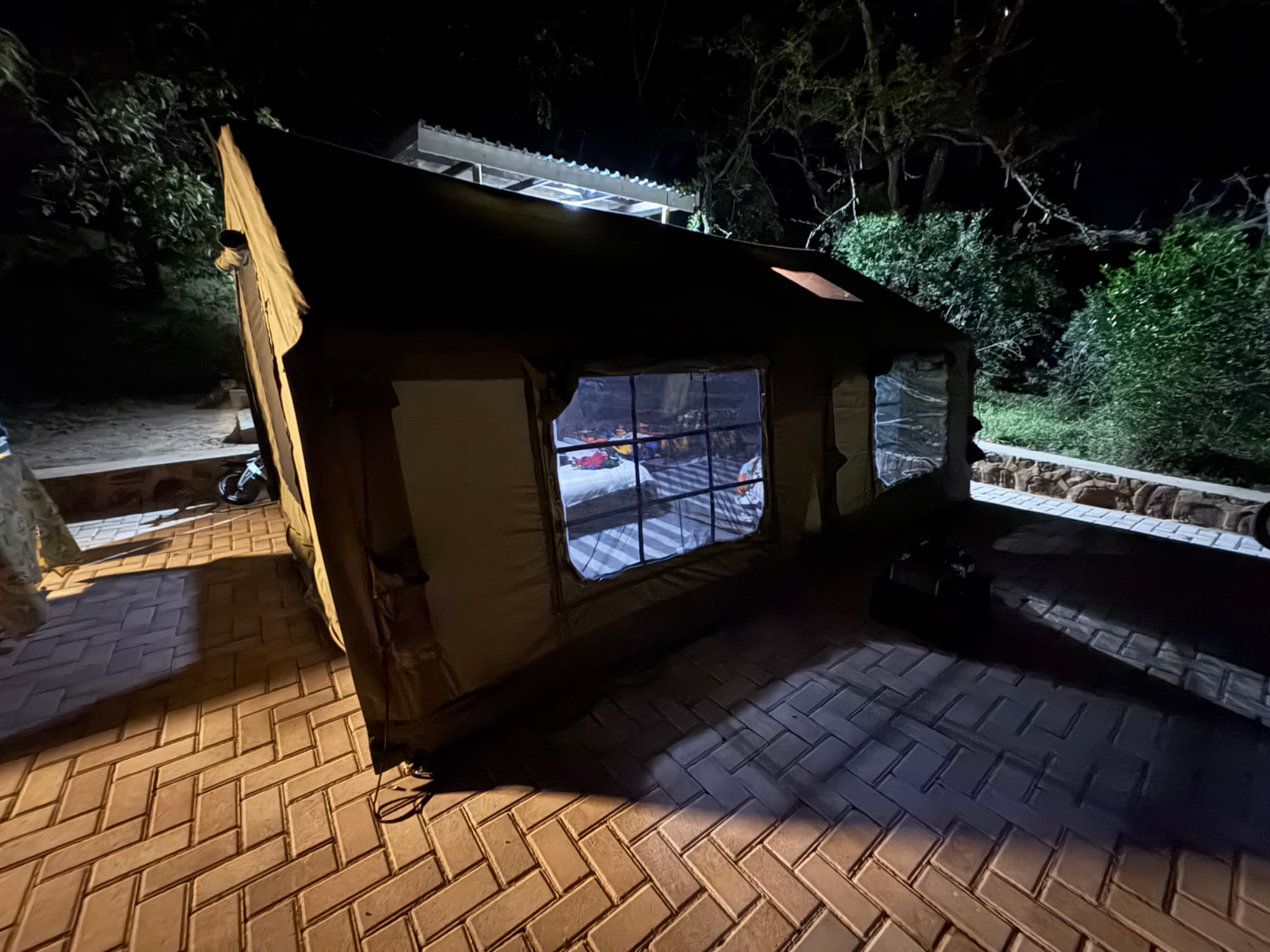 Camp chairs, cooler fridge, and gear set up outside the Coody tent at Kleinood