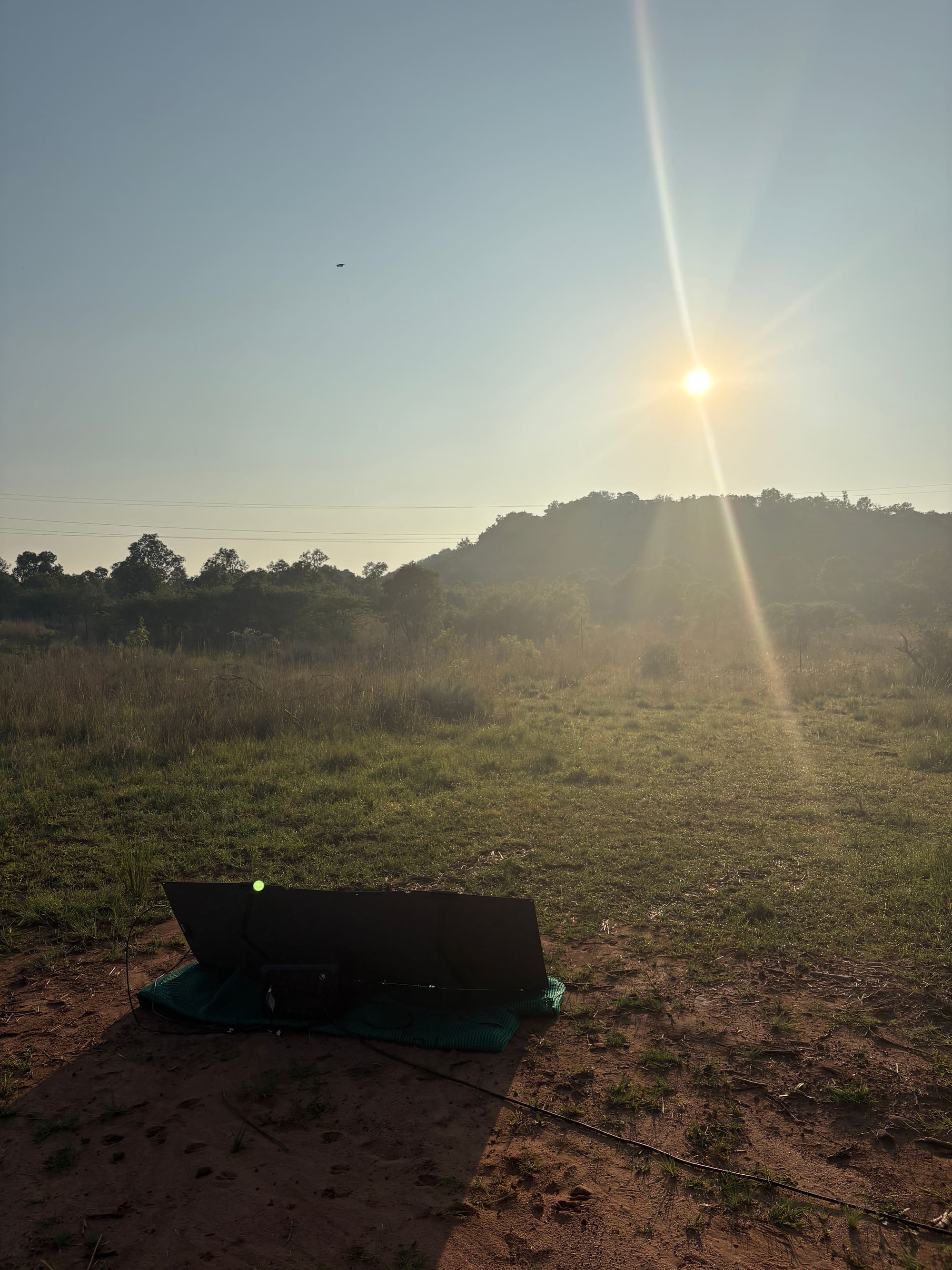 Sunrise over the field at Kleinood Guest Farm with a portable solar panel set up on the ground