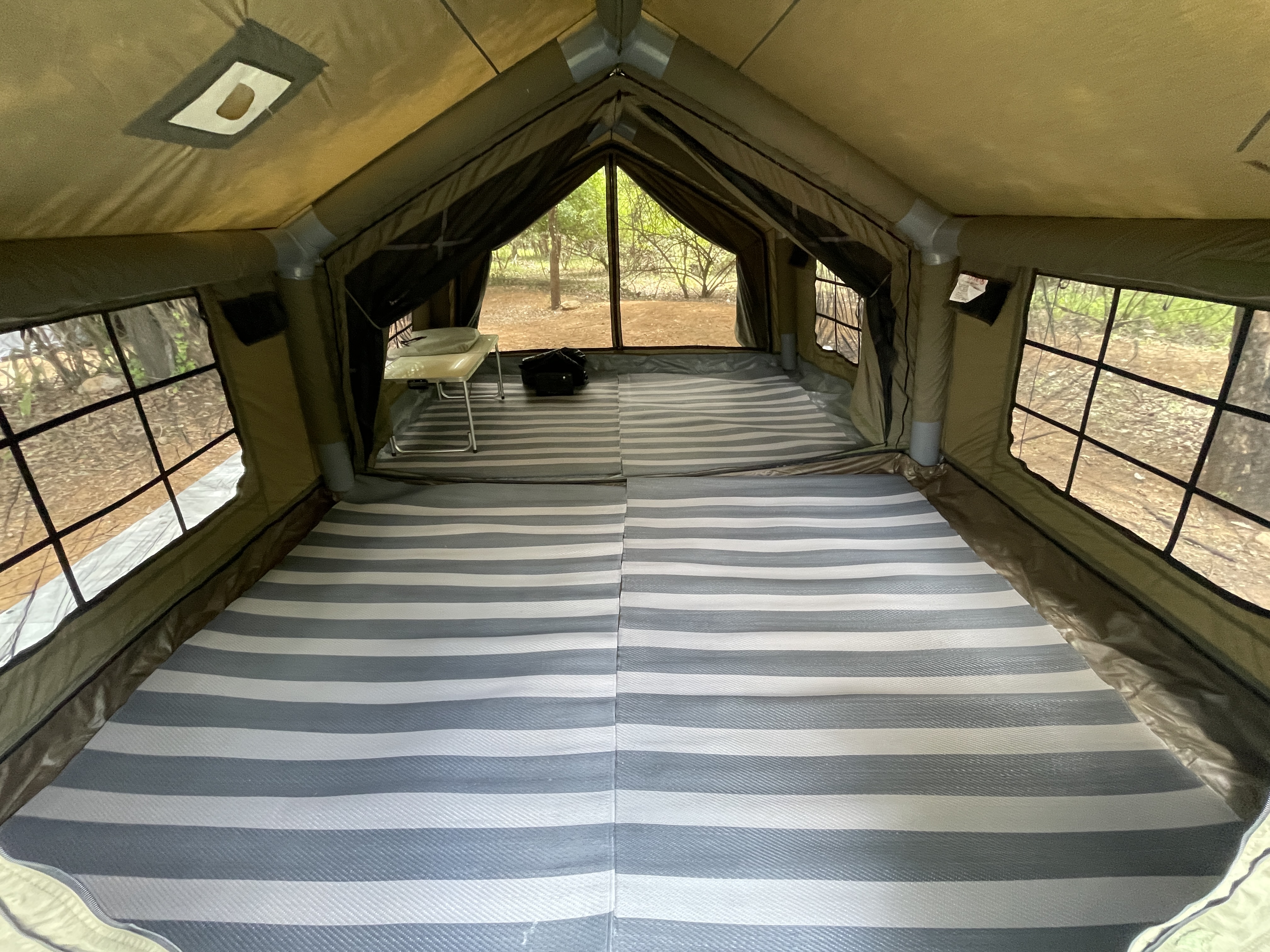 Interior of the Coody Familia inflatable tent fully set up at Berg en Dal, carpets laid across the entire floor