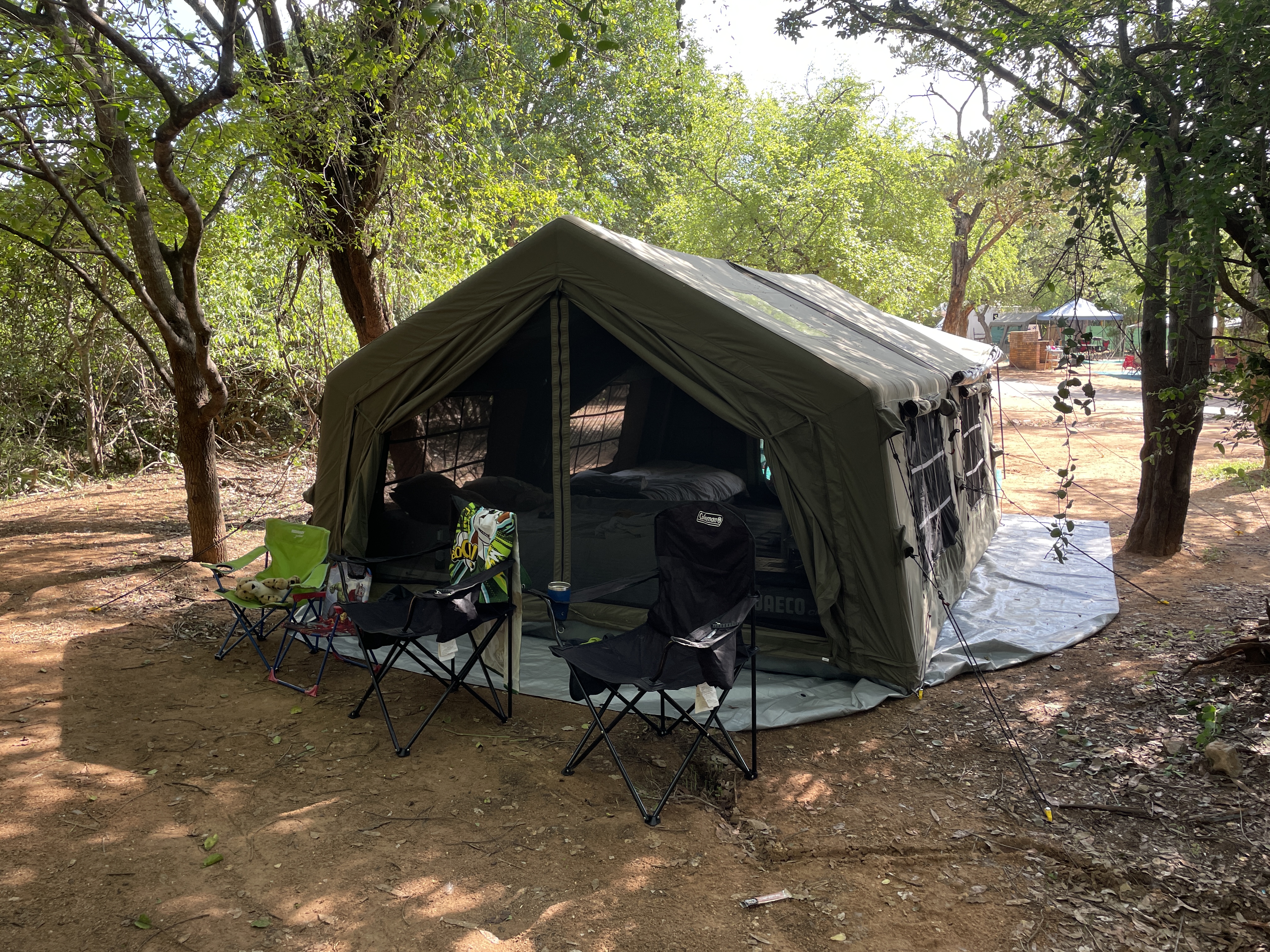 Coody Familia tent set up at Berg en Dal campsite with chairs and table arranged outside in the shade