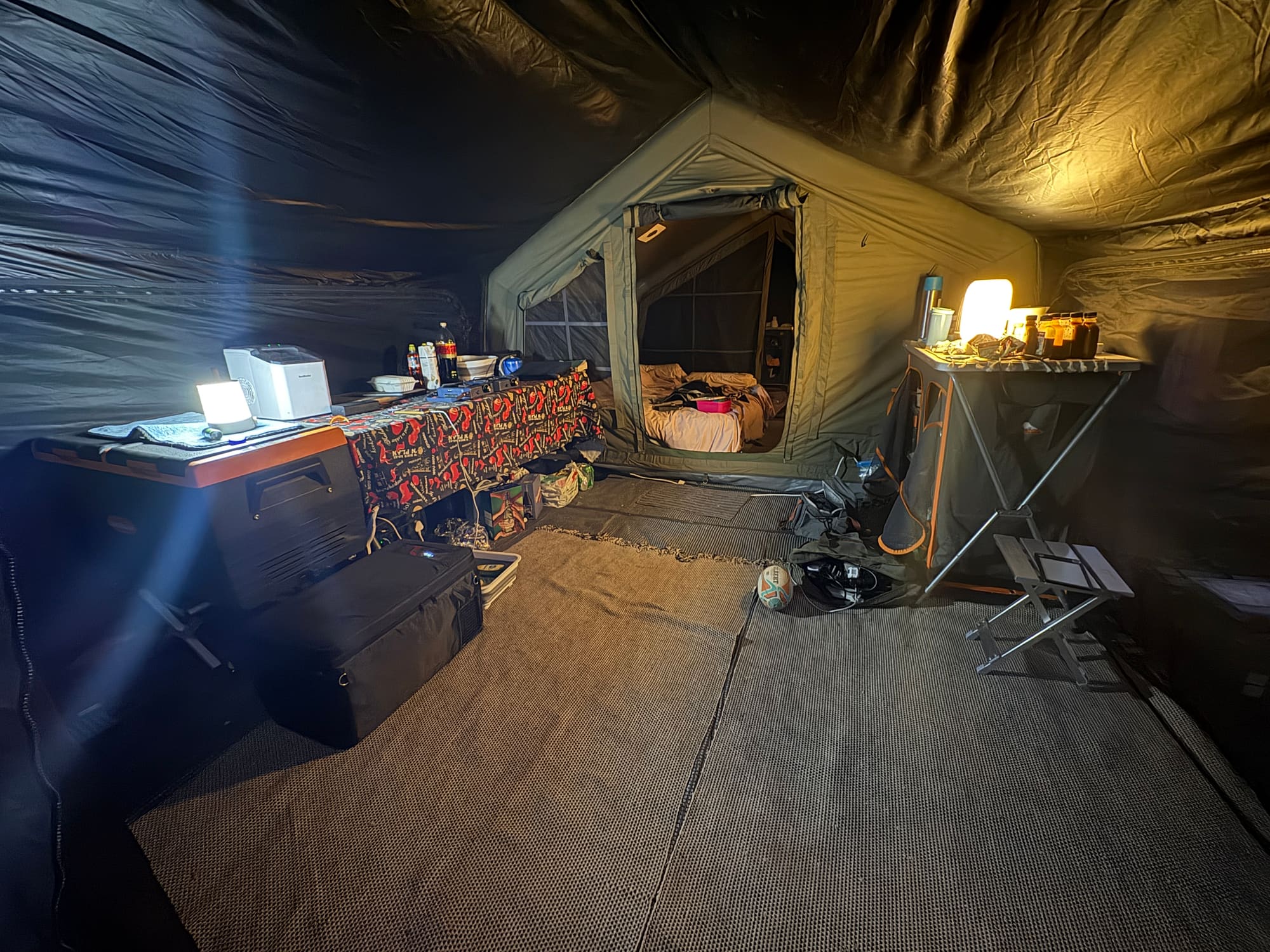 Interior of the Coody tent's annex at night, drinks and camp kitchen set up