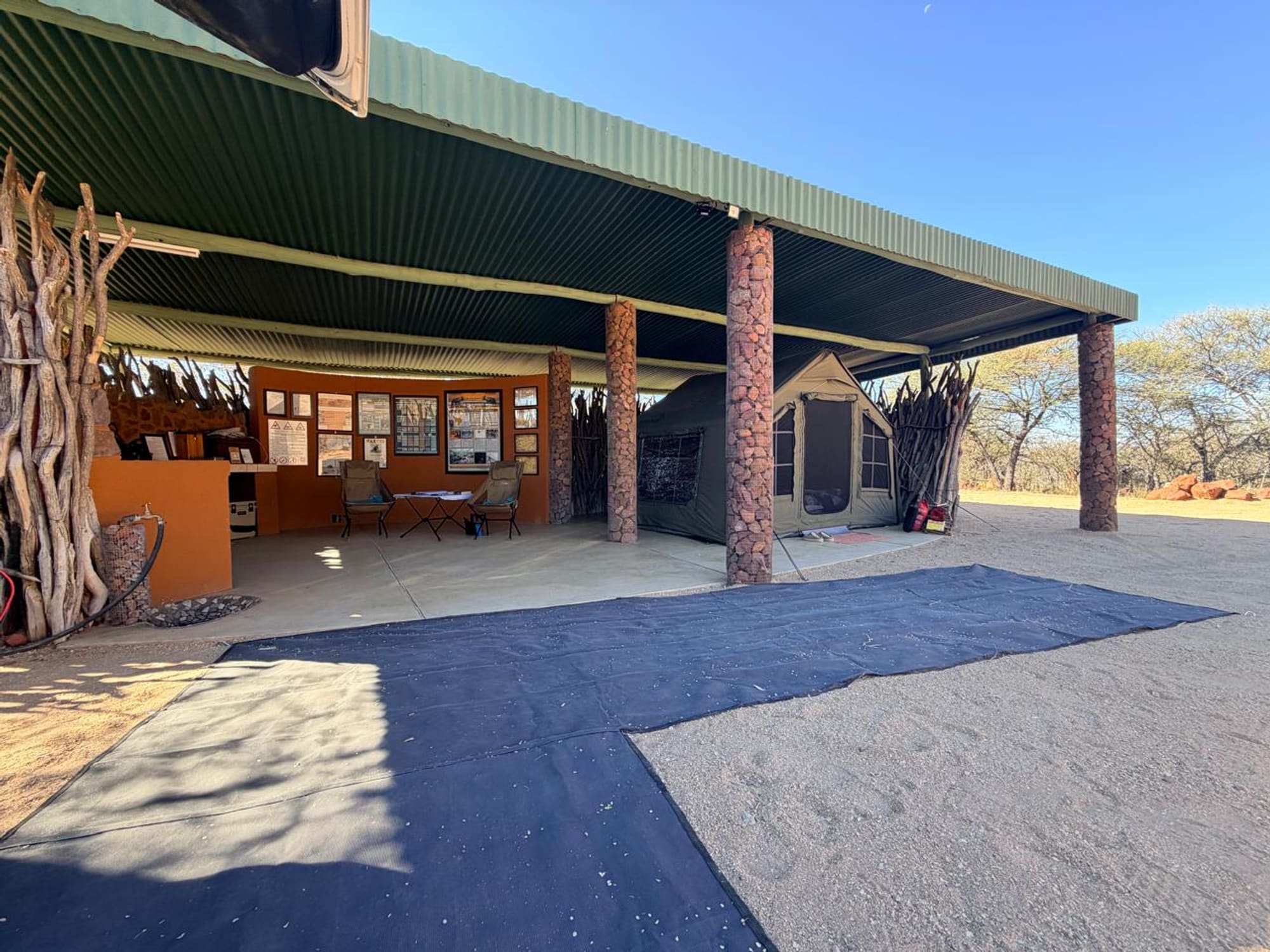 Wide view of the covered campsite shelter at Okonjima, Namibia, with the Coody 8 tent pitched under it