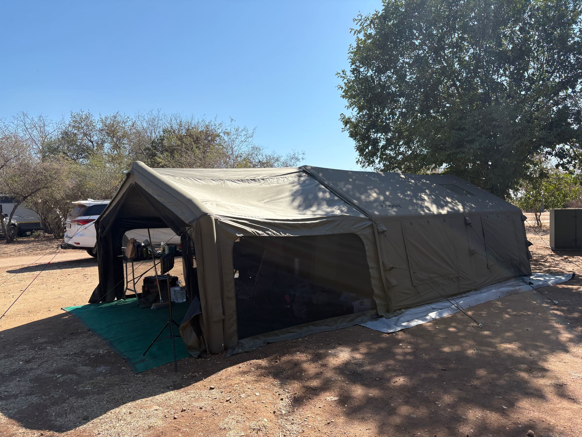 Coody Familia tent at Satara with camper trailers and vehicles visible in the background