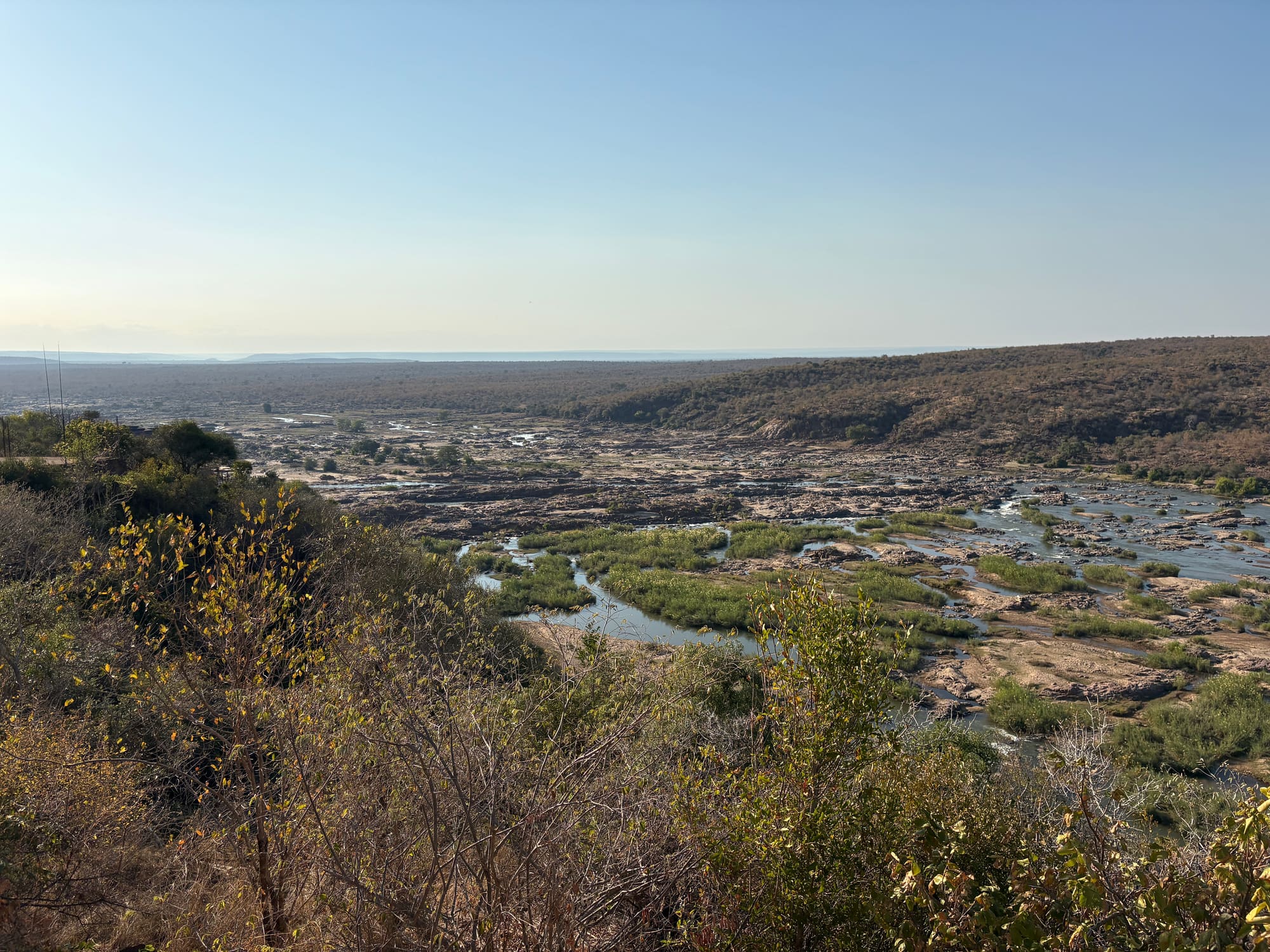 Wide view over a dry riverbed and valley near Satara