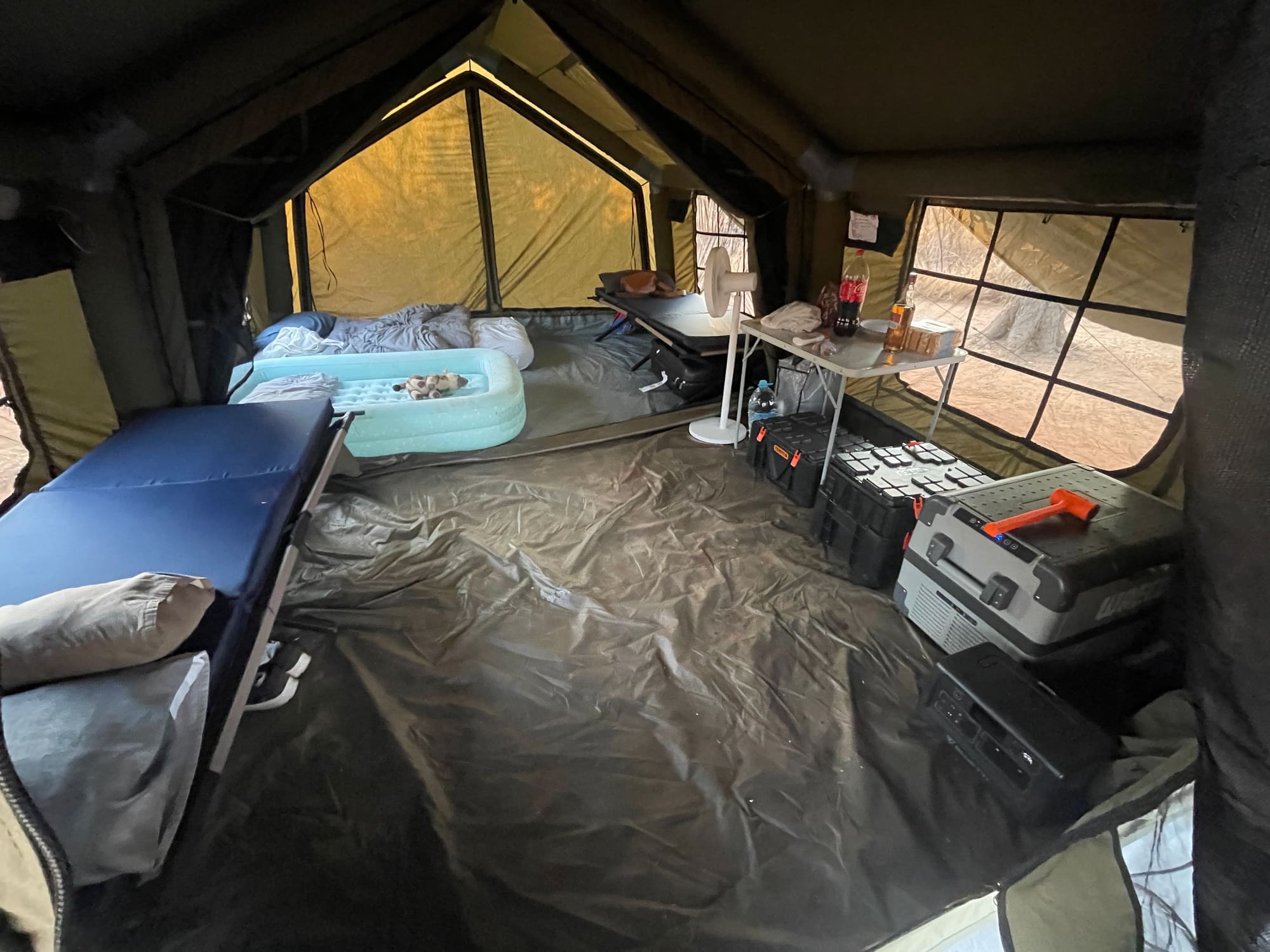 Interior of the Coody Familia tent set up for a family, beds and kids' gear visible