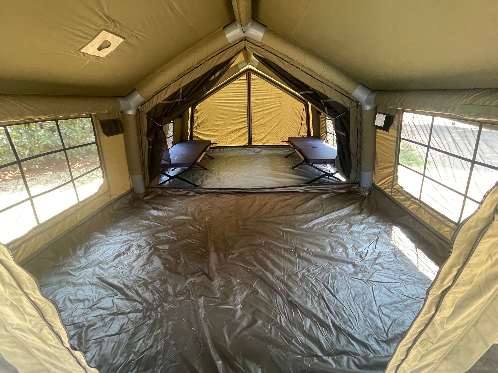 Interior of the Coody Familia tent freshly set up with camp cots, ready to move in