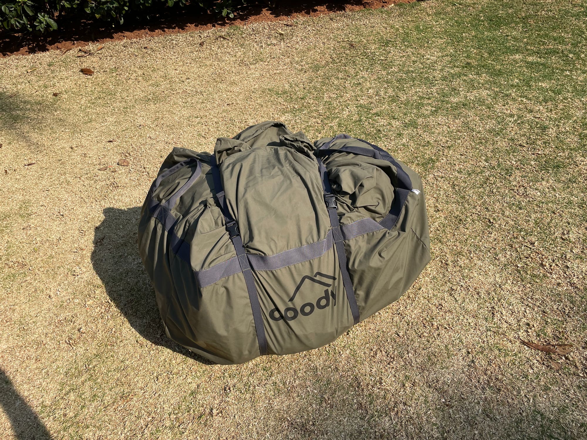 Coody tent bag packed on the grass before setup