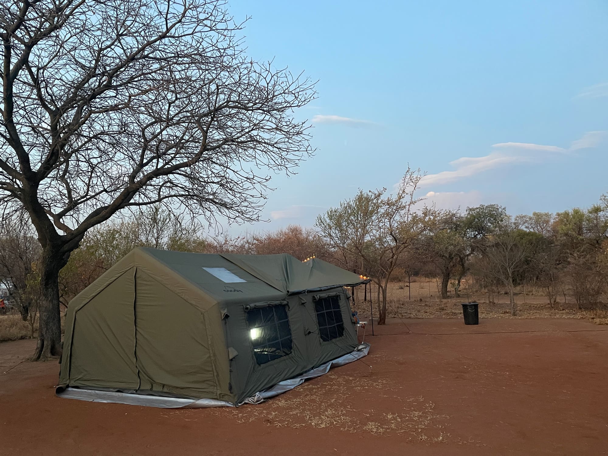Coody Familia tent at twilight with string lights along the roofline at Willemsrus, Dinokeng