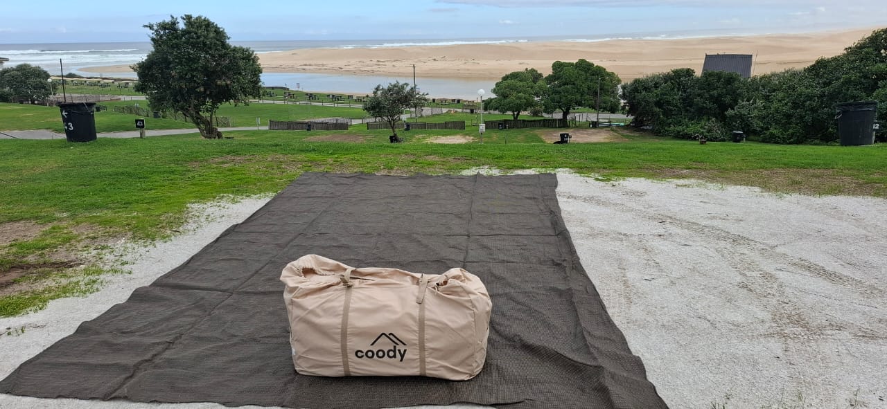 Howard's beige Coody 8, packed up on a groundsheet overlooking the beach in Gqeberha