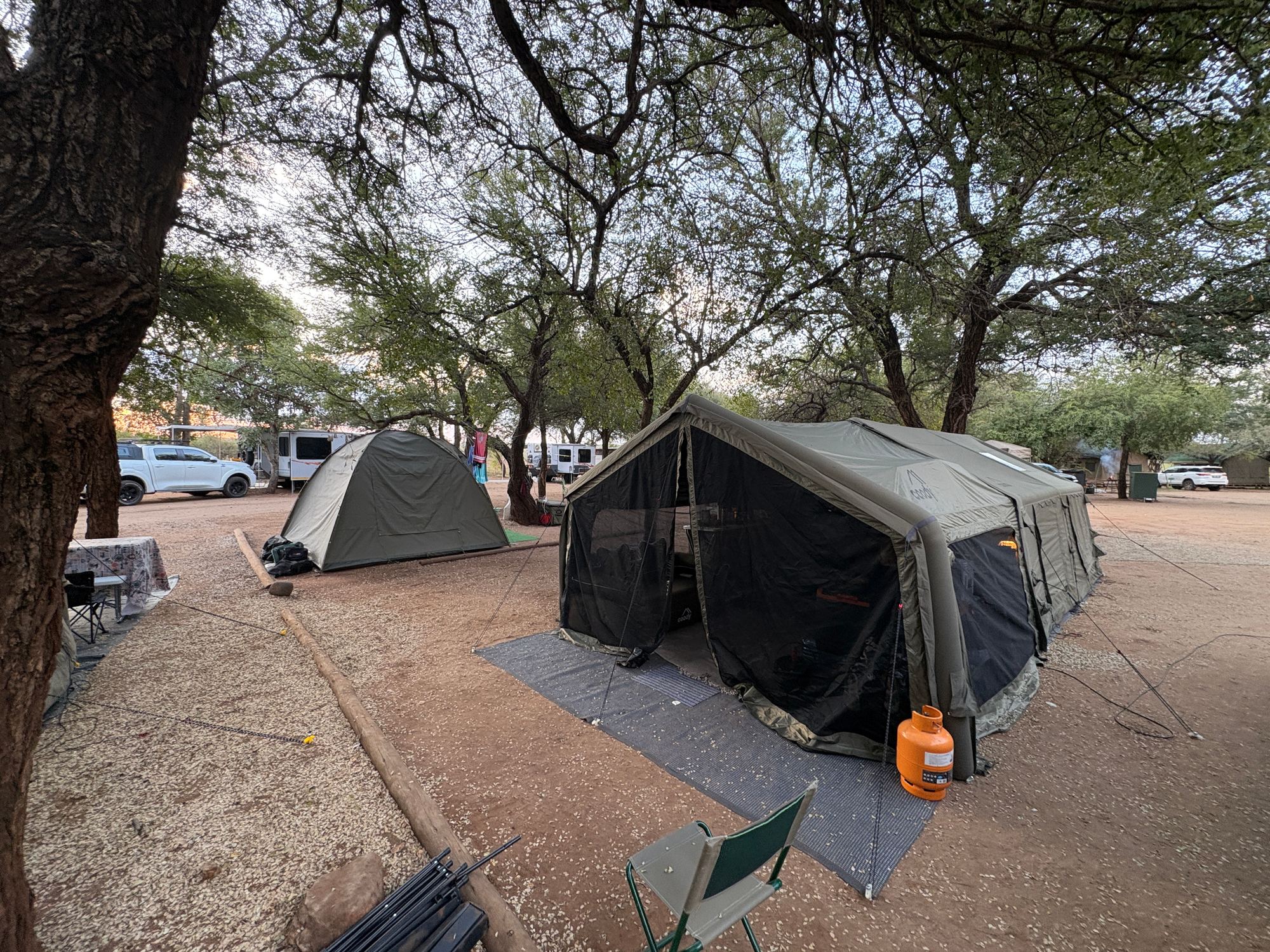 Martin's army green Coody Familia with Canopy set up under the trees at a campsite