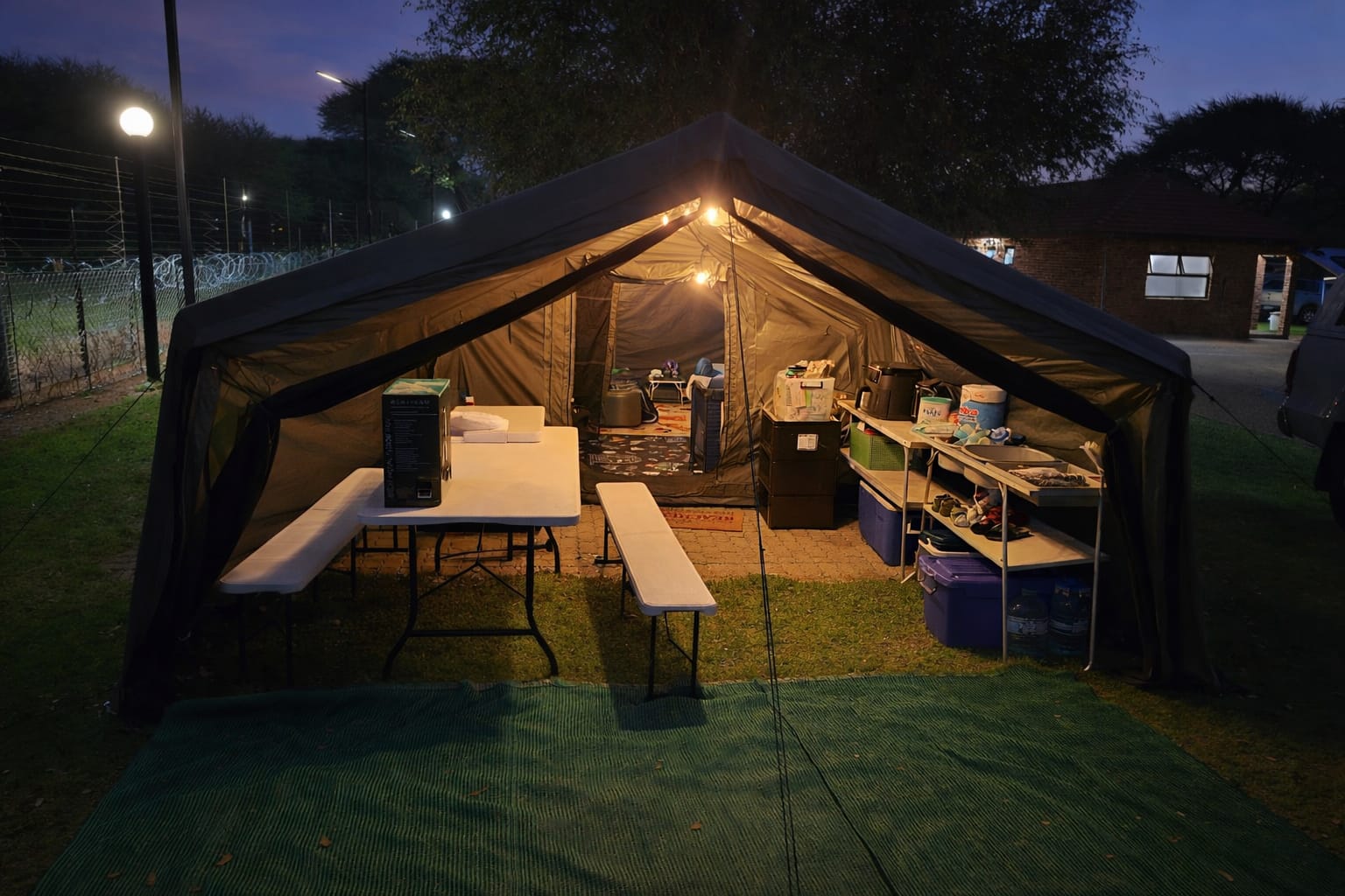 Wihan's army green Coody Familia with Canopy set up at dusk, tables and gear packed inside